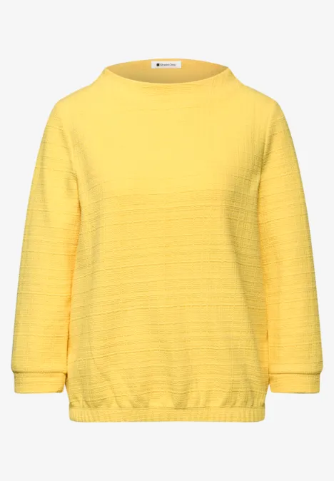 Gelbes Sweatshirt mit Rundhalsausschnitt, langen Ärmeln und dezentem Querstrukturmuster.